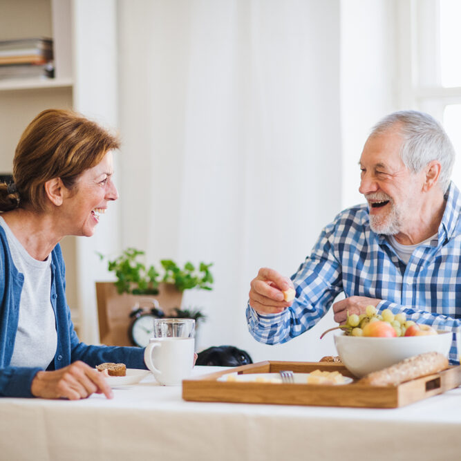 A,Senior,Couple,Sitting,At,The,Table,At,Home,,Having